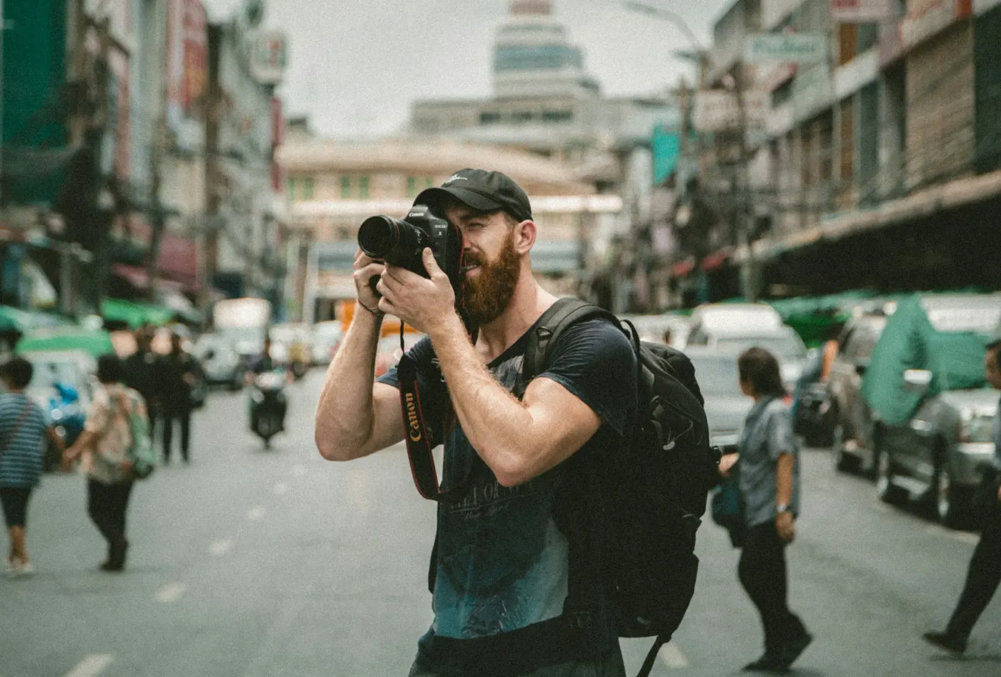 Kalabalık bir caddede çekim yapan fotoğrafçı