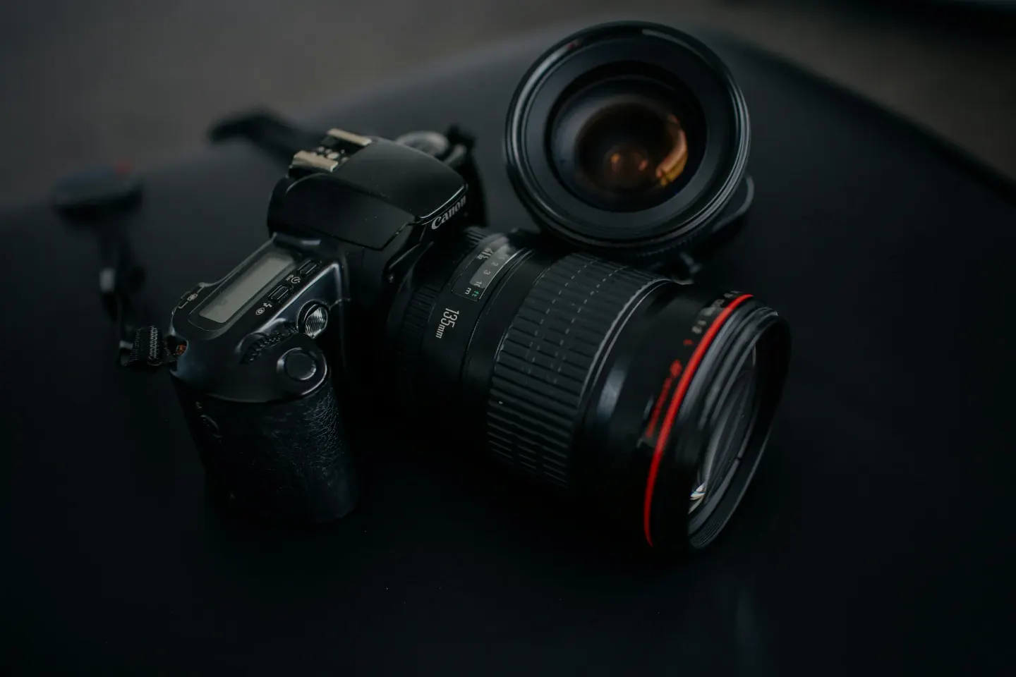 Siyah zeminde kırmızı halkalı lensli aynasız fotoğraf makinesi